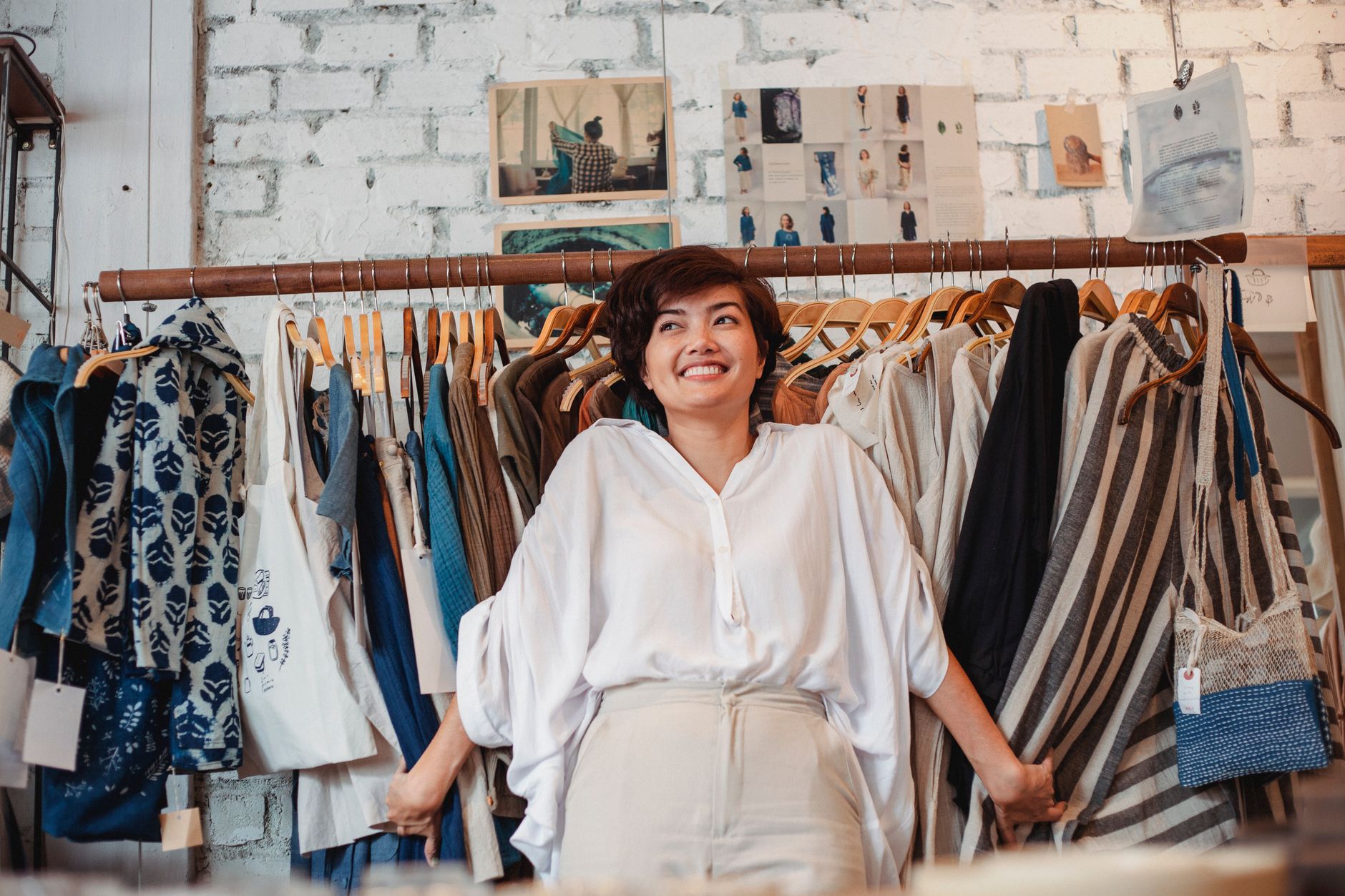 Person standing by clothing racks in a shop